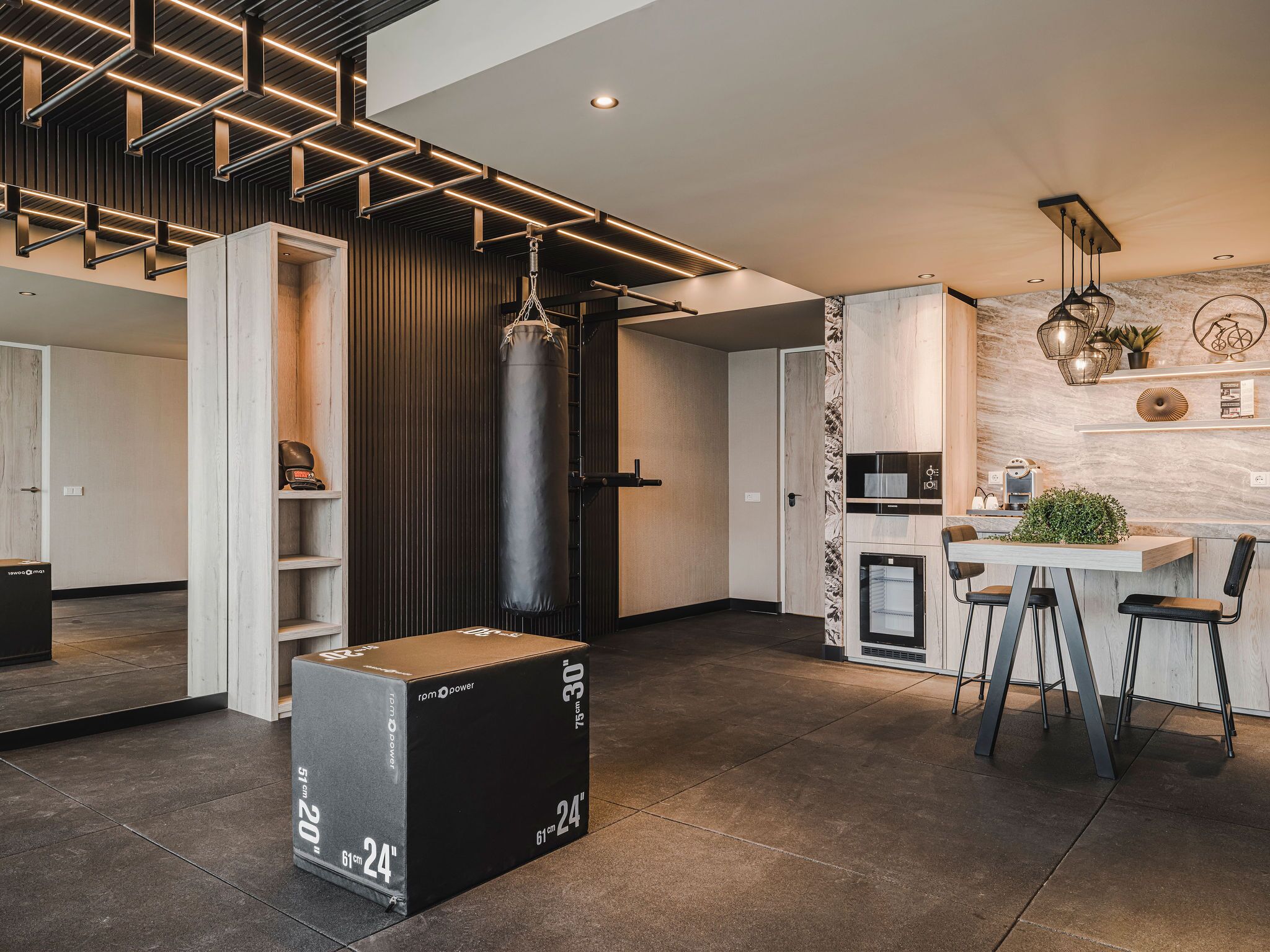 A modern kitchen with a dining area, a punching bag, and a large black box labeled "rom power".