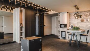 A modern kitchen with a dining area, a punching bag, and a large black box labeled "rom power".