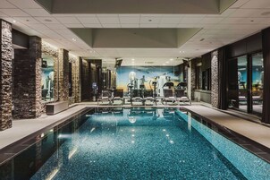 Una piscina techada, sillones reclinables de piscina