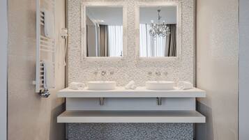 Un baño moderno con dos lavamanos, un espejo grande y un perchero para toallas.