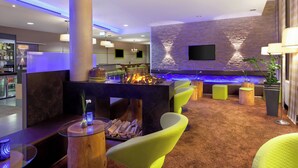 A modern lounge area with a bar, seating, and a stone accent wall.