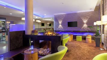 Un área de descanso moderna con bar, asientos y una pared de acento de piedra.