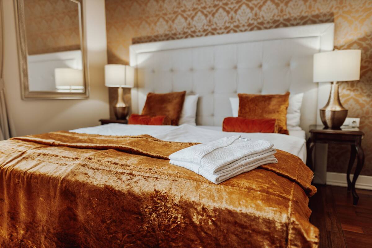 Een hotelkamer met een groot bed, twee nachtkastjes en een hoofdbord.