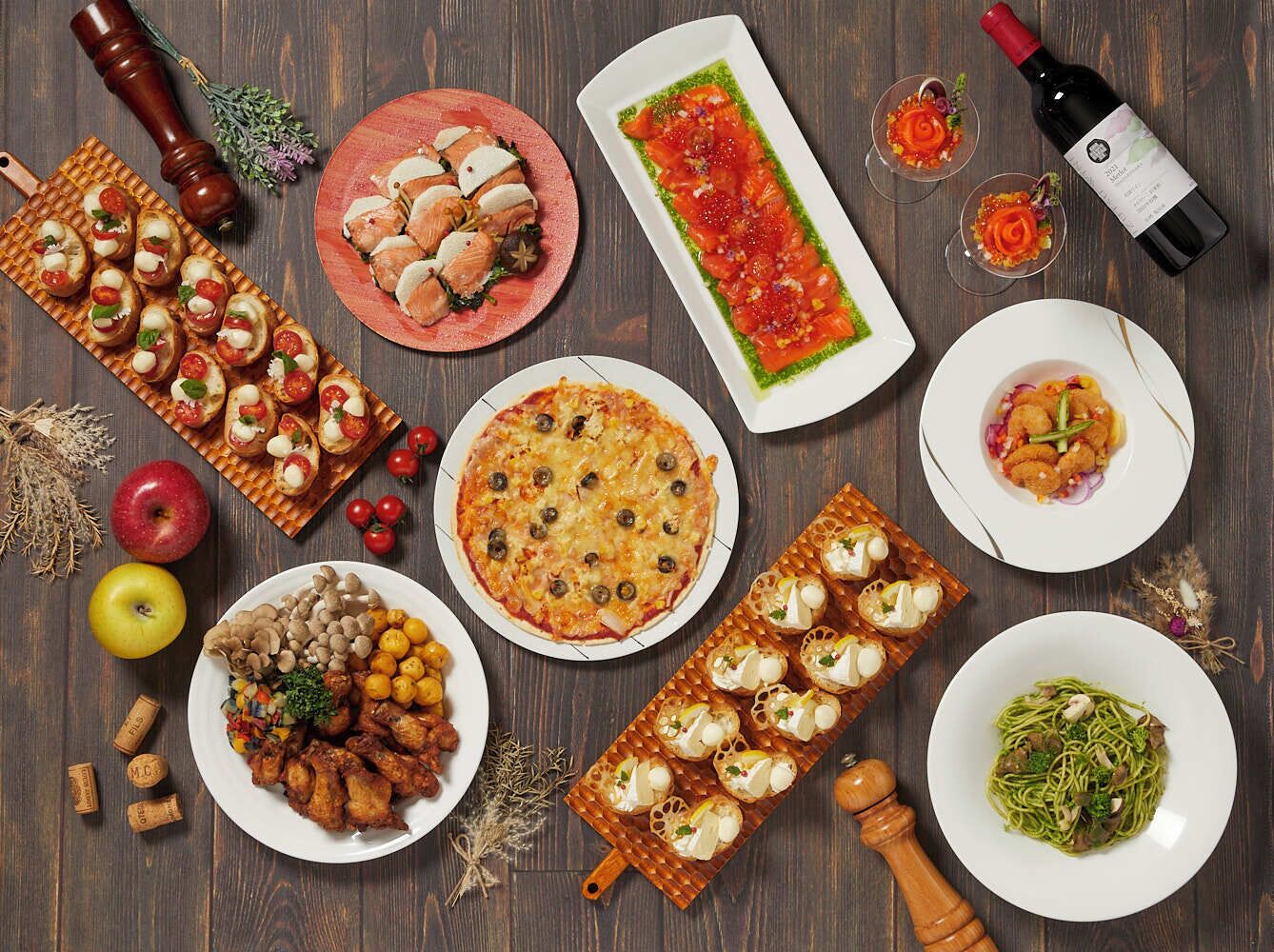 Una variedad de platos, como pizza, bruschetta y ensaladas, dispuesta sobre una mesa de madera.