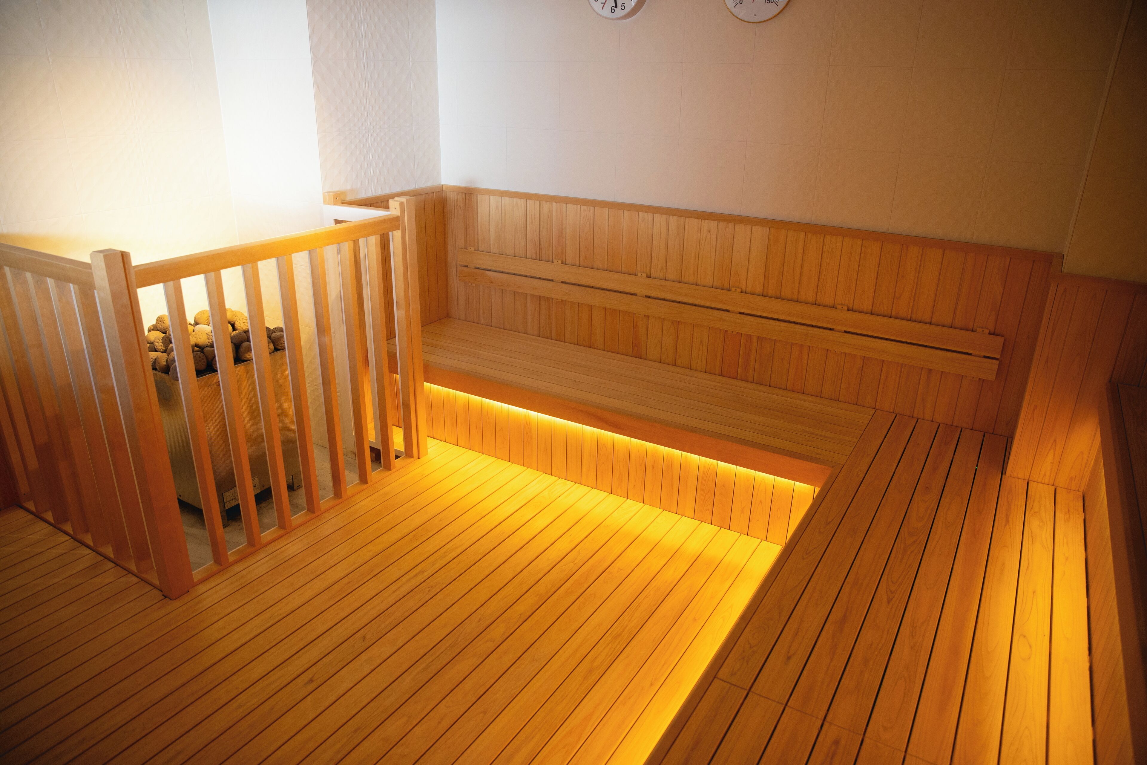 Un sauna en bois, doté de bancs et d’une rambarde en bois.