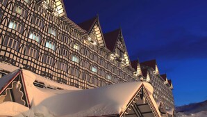 Ein traditionelles Fachwerkhäuschen mit schneebedeckten Dächern und einer gut beleuchteten Fassade.