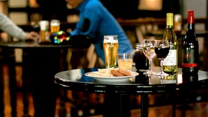 Eine Bar mit einem für zwei Personen gedecktem Tisch, verschiedenen Getränken und einer Platte mit Speisen.
