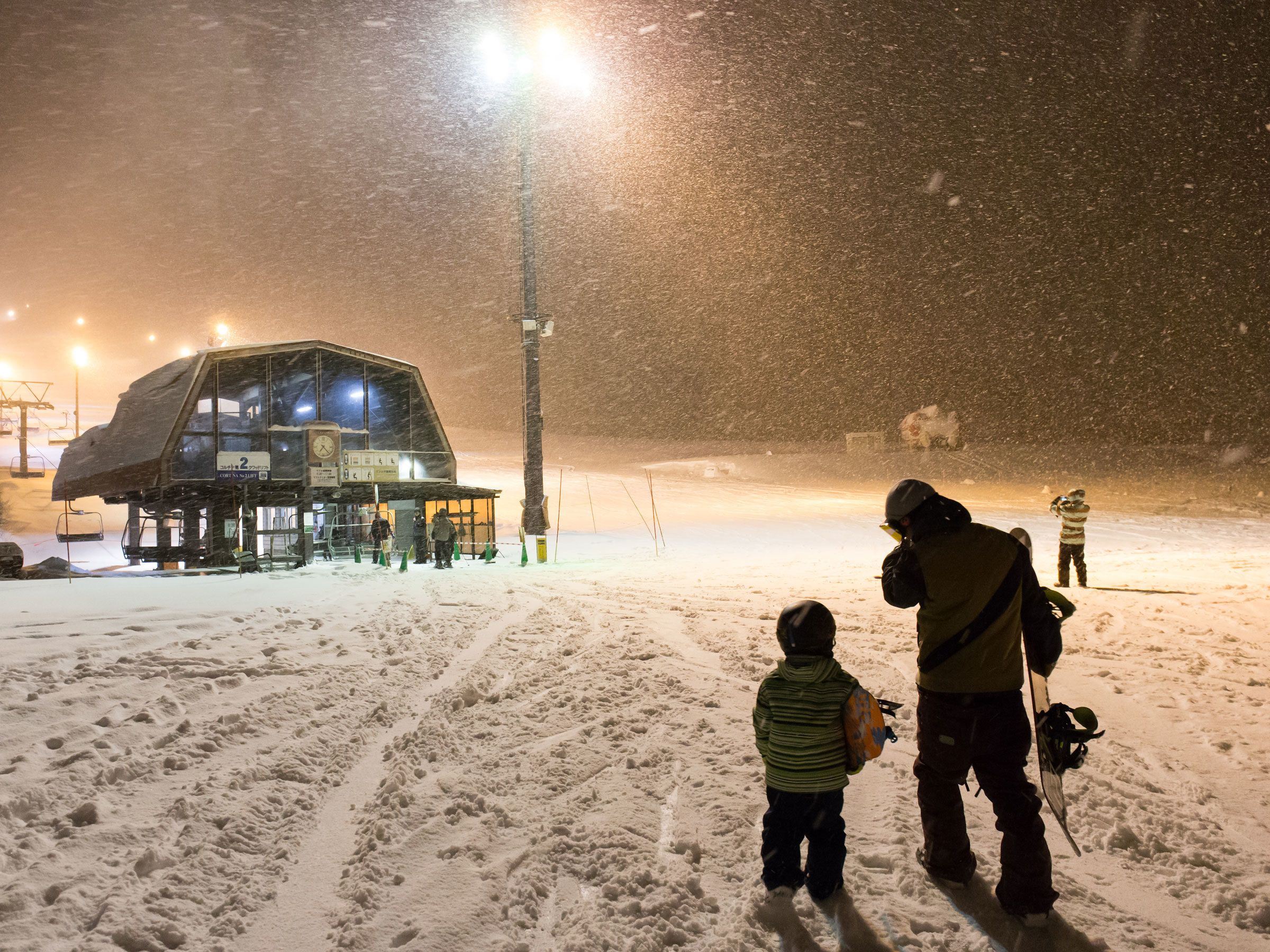 A snow-covered landscape with a ski lift and a building with a large glass facade.