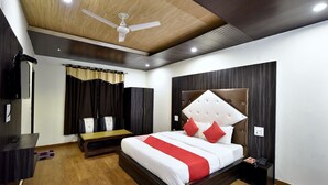 A modern bedroom with a large bed, a ceiling fan, and a wooden floor. - Shining Star Resort (Chamba)