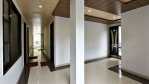 A modern hotel corridor with a wooden ceiling, white walls, and a tiled floor. - Shining Star Resort (Chamba)