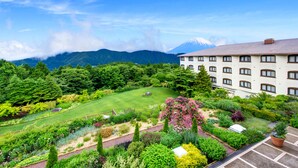 Un hotel con jardín y vistas a la montaña.