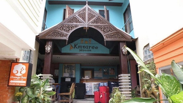 The entrance to Kinnaree House with a signboard, a reception desk, and a few pieces of furniture.