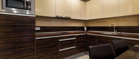 Una cocina moderna con microondas integrado, muebles de madera y un comedor con mesa y sillas.
