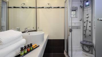 Un baño moderno con un lavamanos grande, espejo y cabina de ducha.