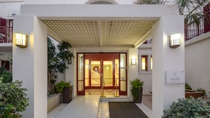 A hotel entrance with a covered walkway, a red carpet, and a sign reading "aeolis boutique hotel". - Aeolis Boutique Hotel (Naxos)
