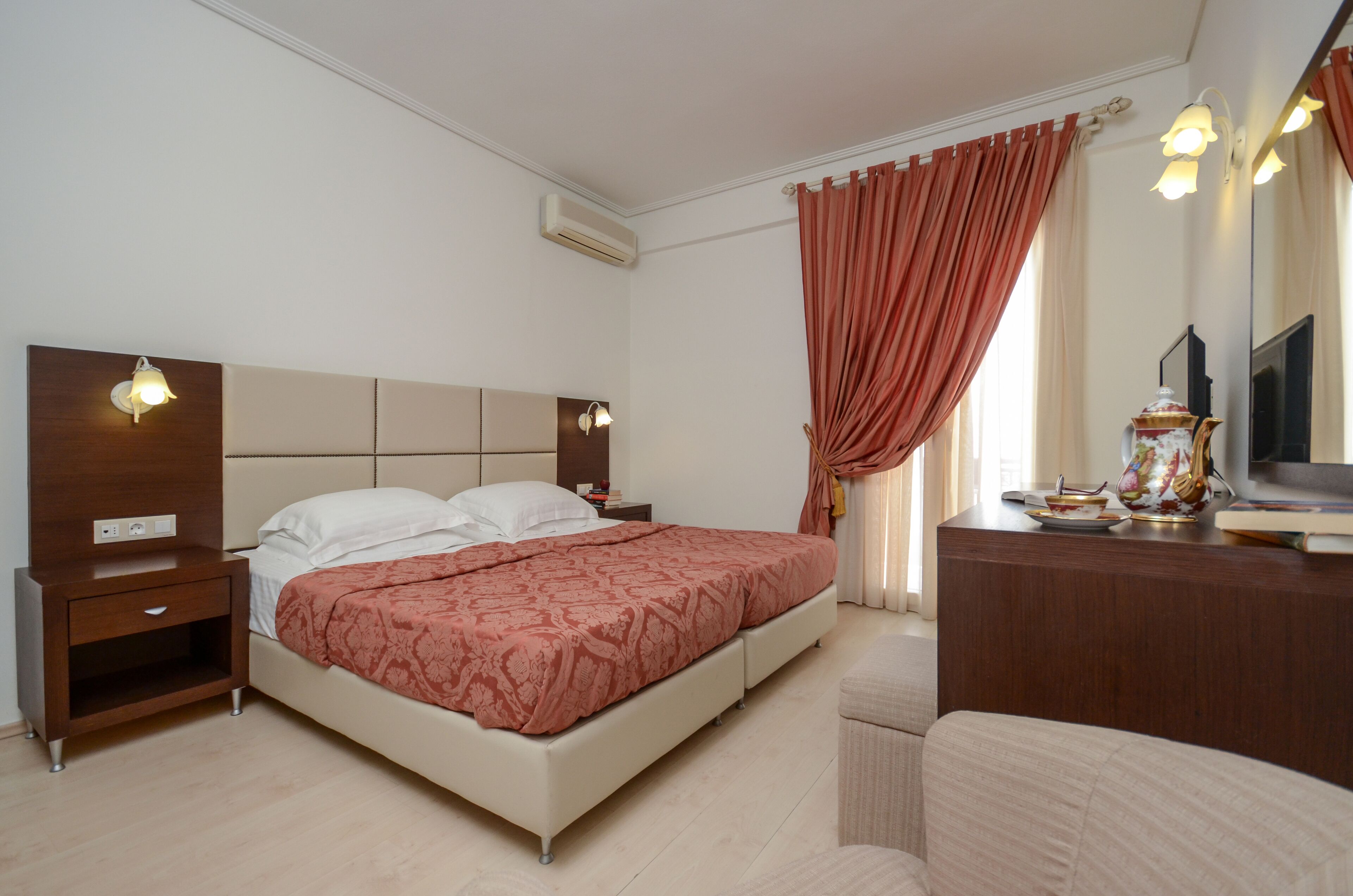 A bedroom with a bed, bedside tables, a dresser, and a mirror.