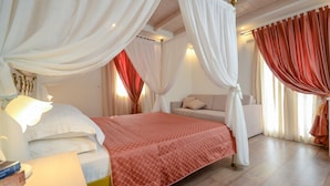 A bedroom with a bed, a nightstand, a lamp, and a window with curtains. - Aeolis Boutique Hotel (Naxos)