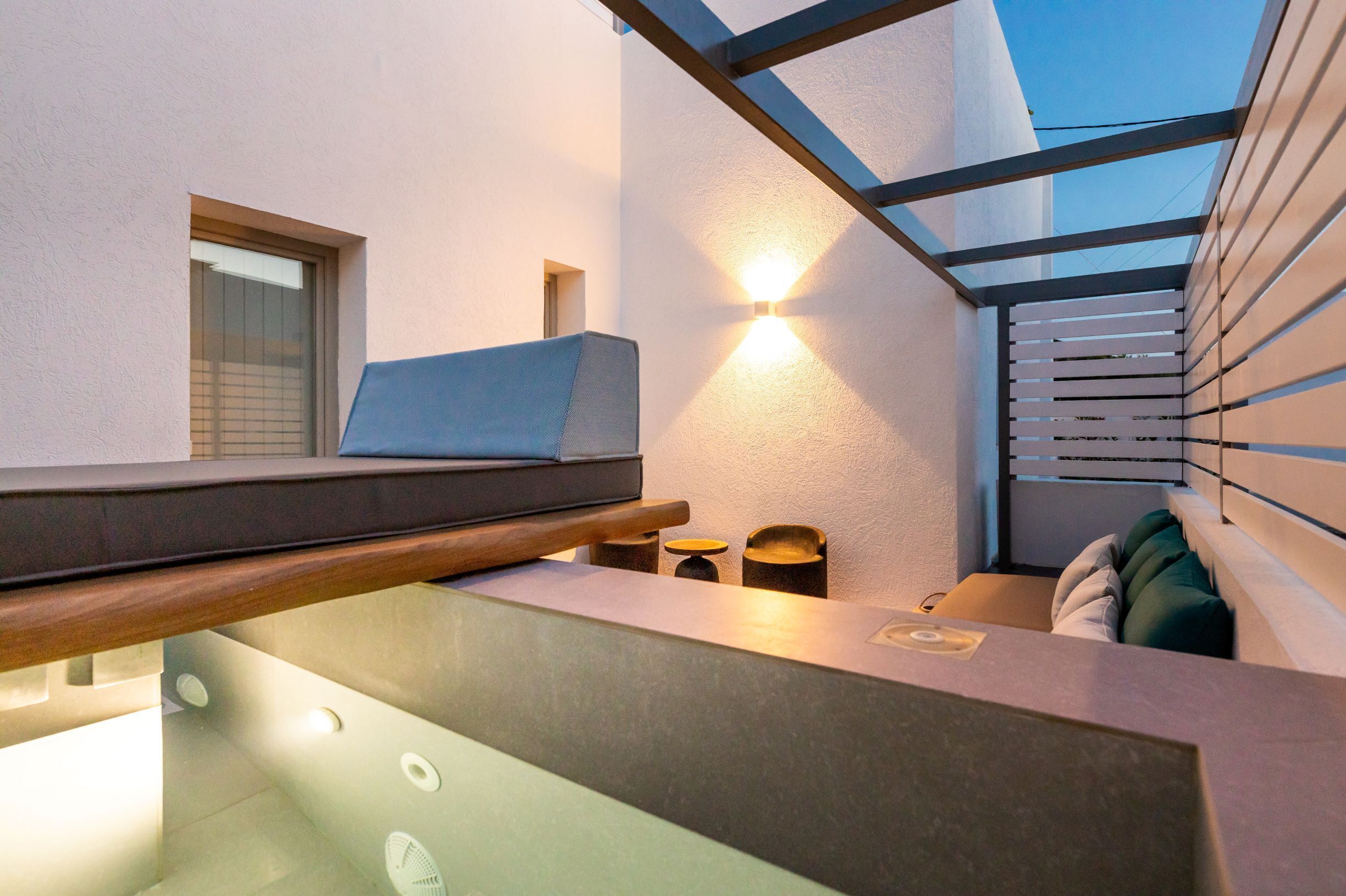 Un intérieur moderne avec un banc intégré, un luminaire fixé au mur et une fenêtre.