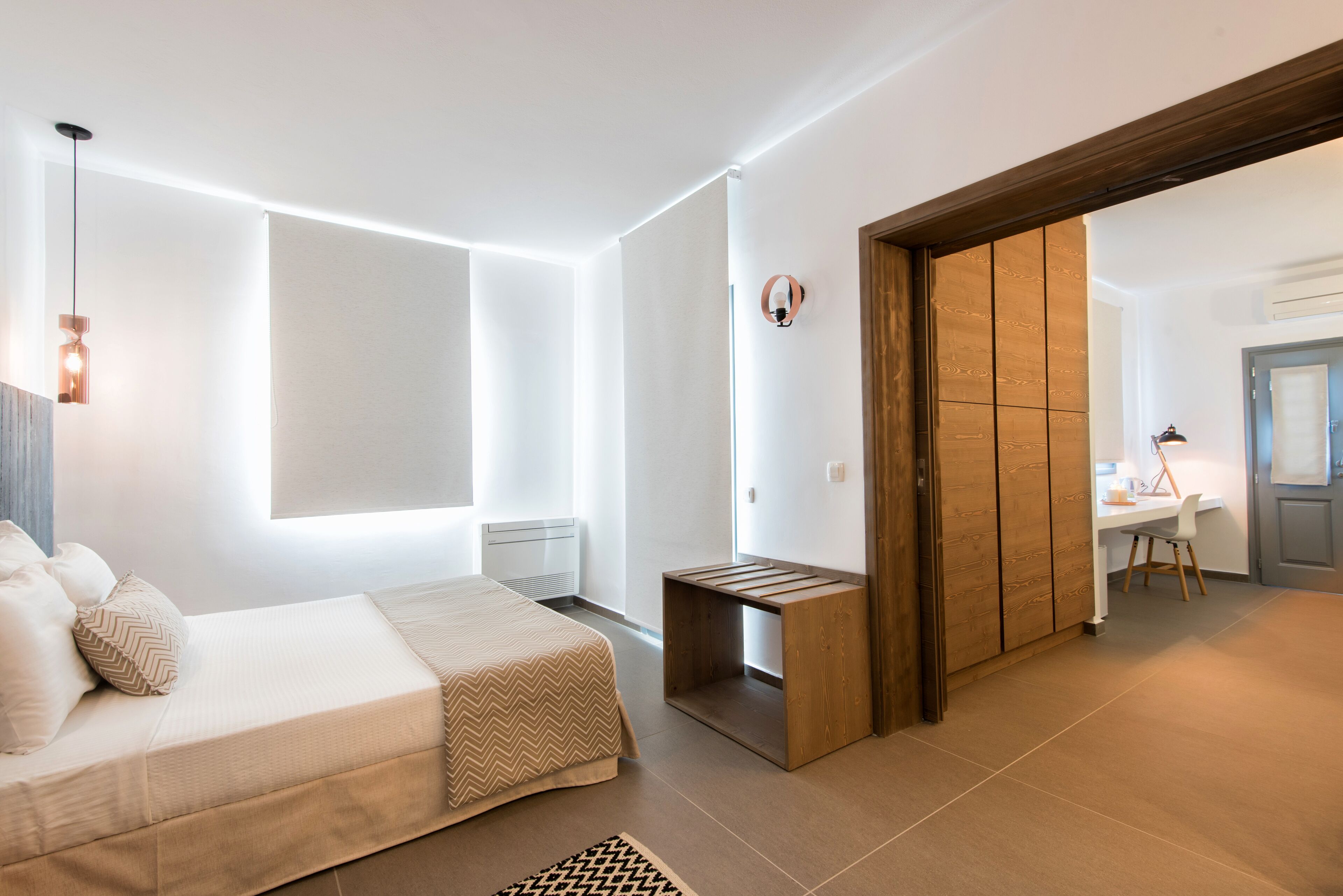 A modern bedroom with a bed, bedside table, and a wooden wardrobe.