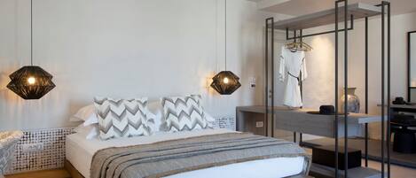 A modern bedroom with a large bed, two pendant lights, a wooden headboard, a mirror, and a built-in wardrobe.