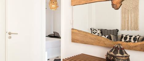 A room with a wooden console table, a decorative bowl, a hanging light fixture, and a mirror with a wooden frame.