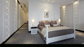 A modern bedroom with a large bed, bedside tables, and decorative wall panels.