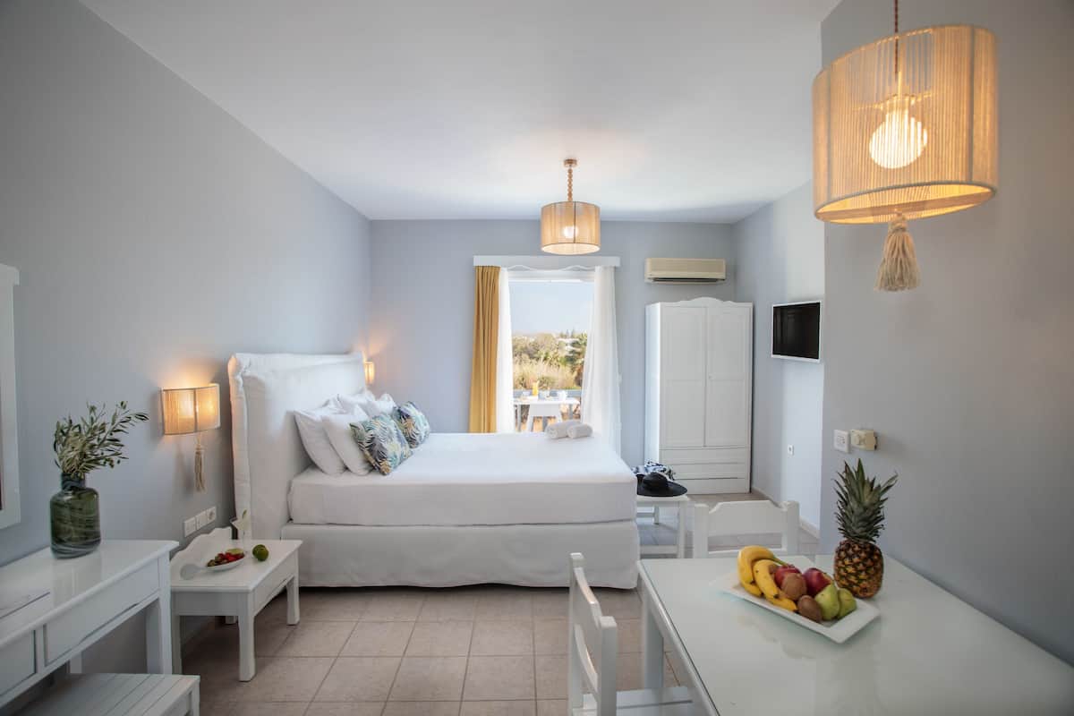 A modern bedroom with a bed, bedside table, and a fruit bowl on a table.