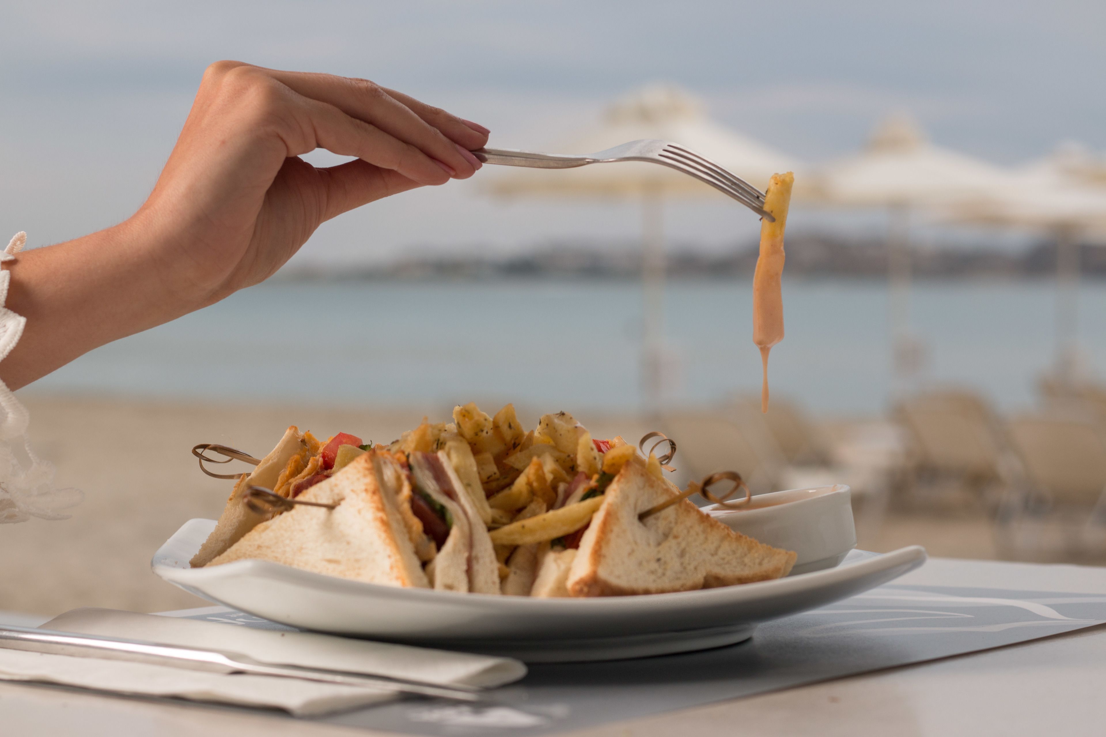 A plate of sandwiches and fries with a fork.