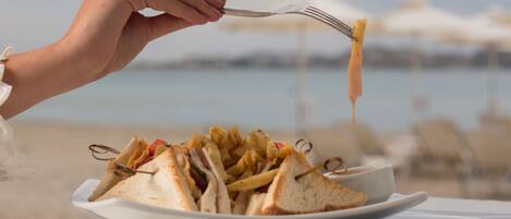 A plate of sandwiches and fries with a fork.