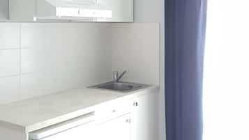 Eine moderne Küche mit weißen Schränken, einer Edelstahlspüle und einem blauen Vorhang.