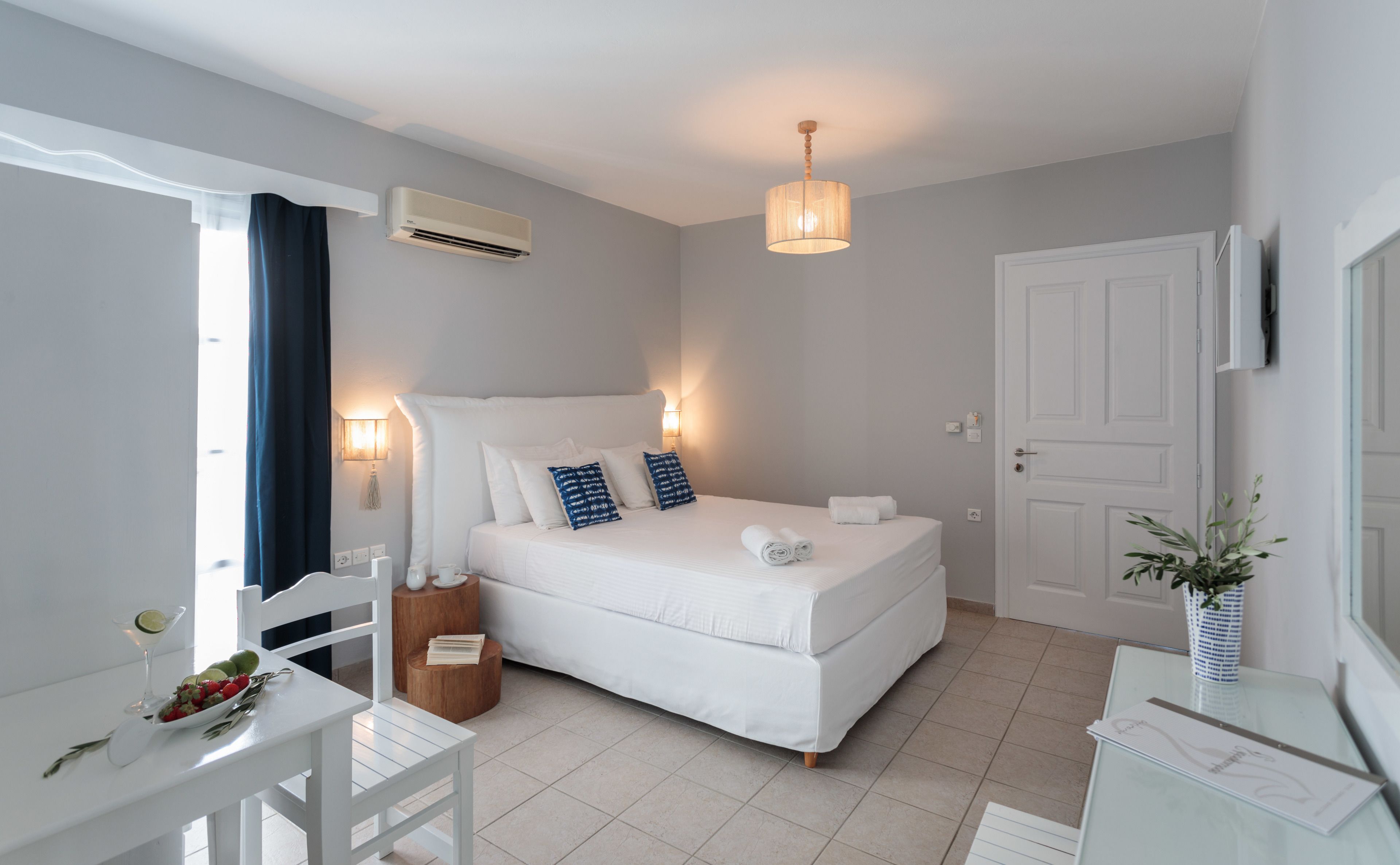 A modern bedroom with a bed, bedside tables, a desk, and a chair.