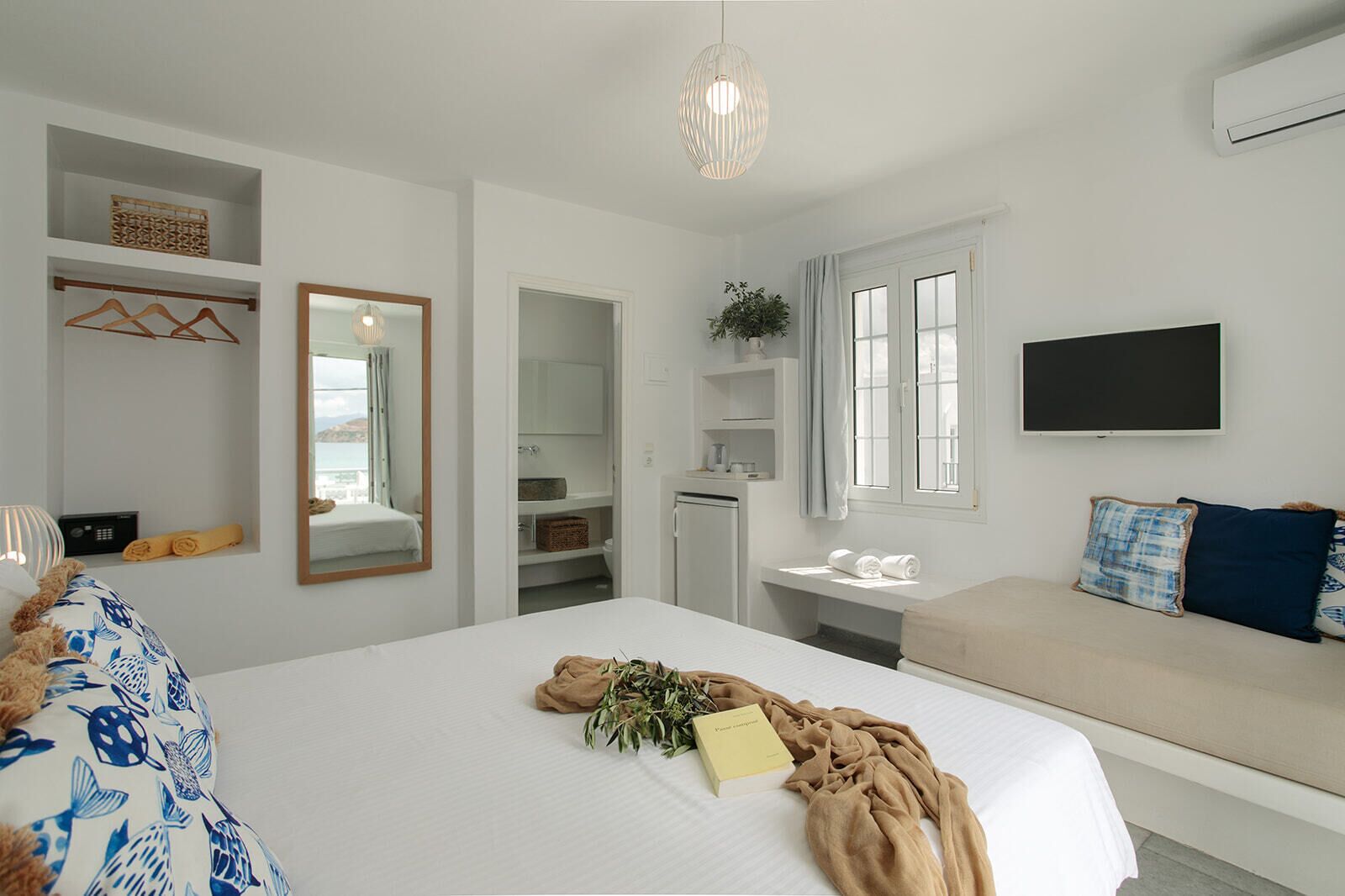 A bedroom with a bed, bedside table, and a TV mounted on the wall.