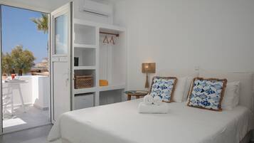 Une chambre d’hôtel avec un lit, une armoire, une petite table avec une lampe et une vue sur l’extérieur.