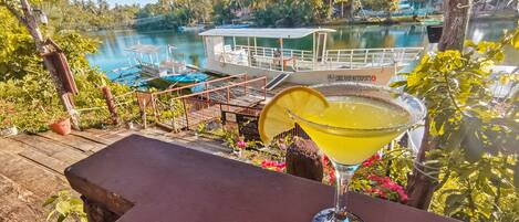 A tropical outdoor setting with a table and a cocktail glass.