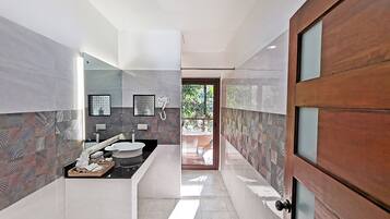 Un baño moderno con tocador, lavamanos y espejo.