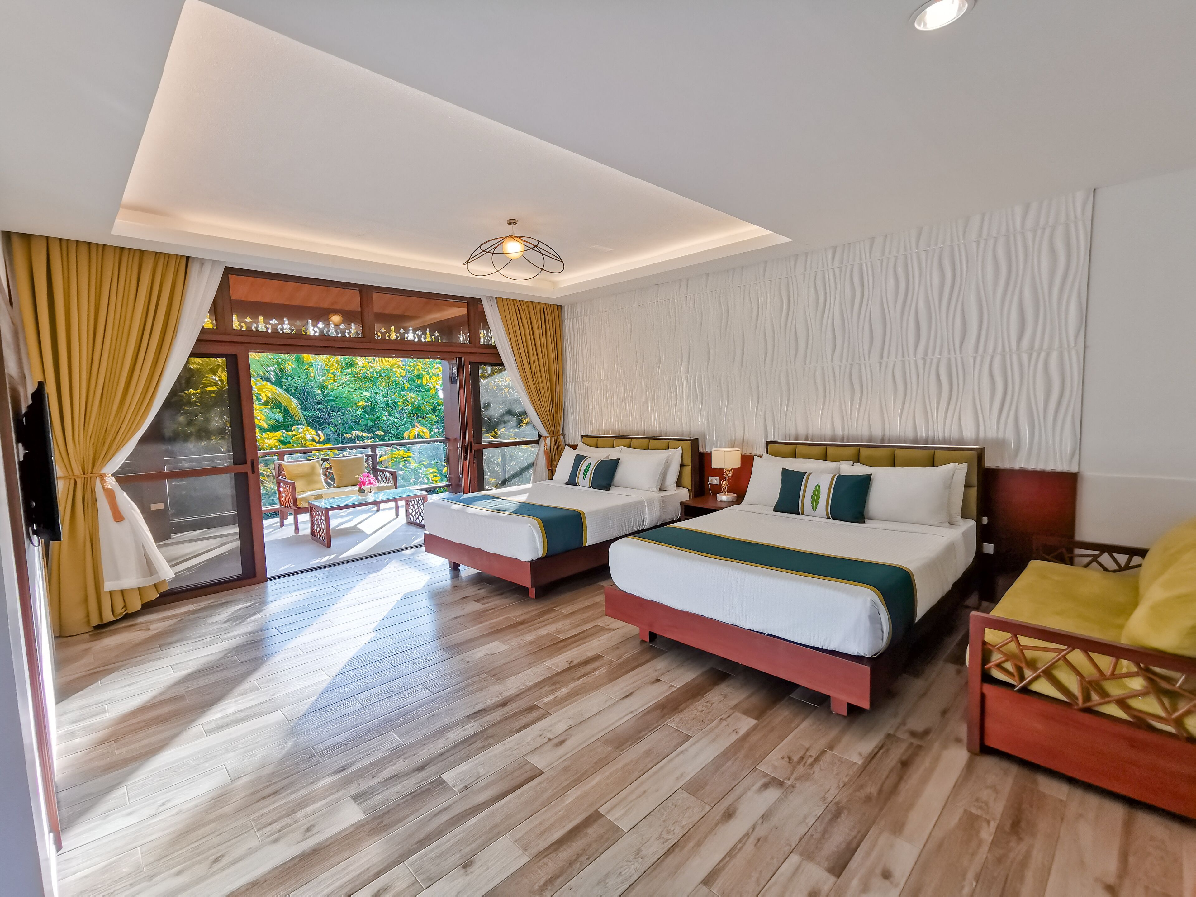 A hotel room with two beds, a balcony, and a view of greenery.