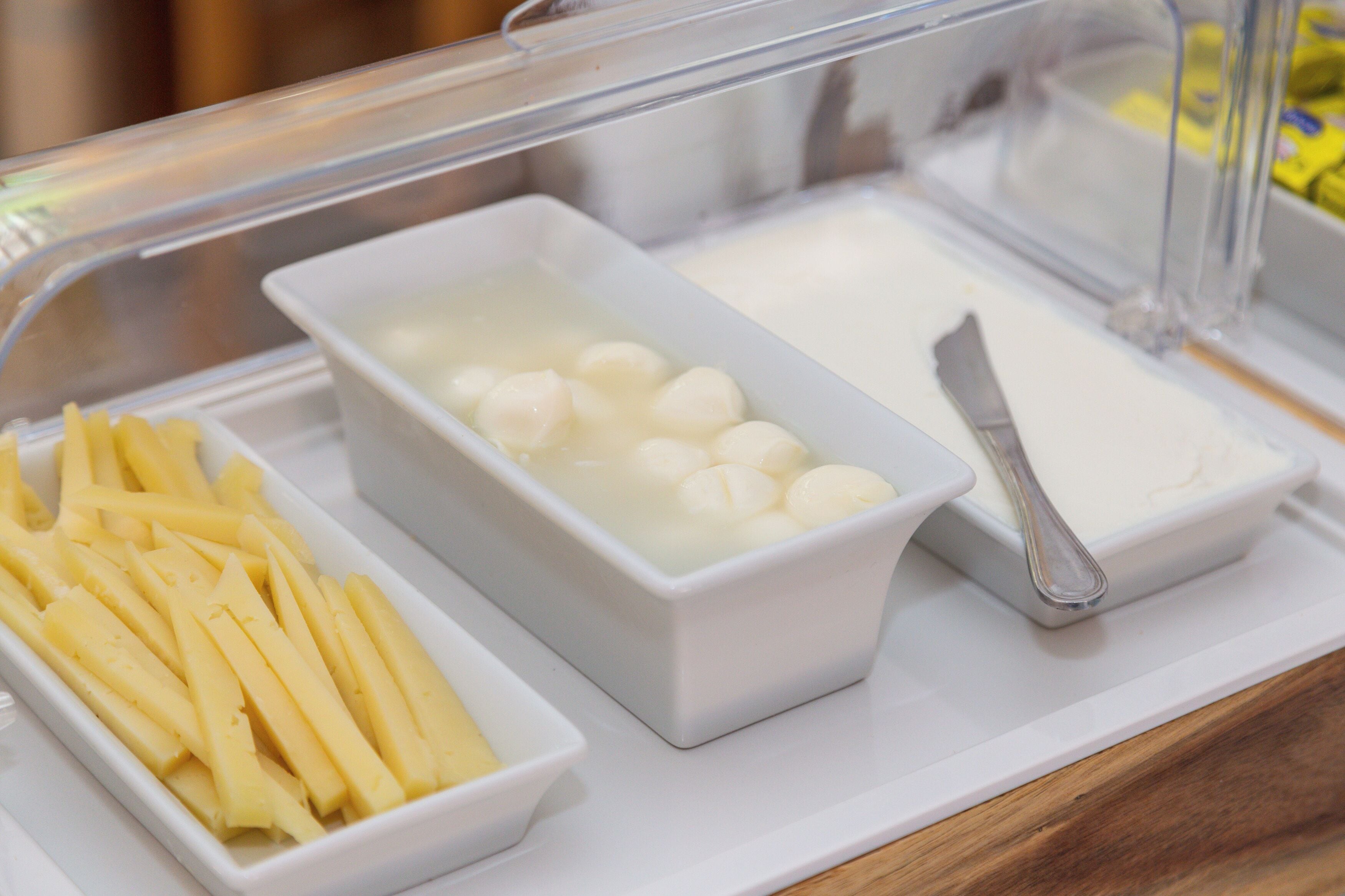 A buffet with various food items including French fries, a bowl of white balls, and a white sauce.