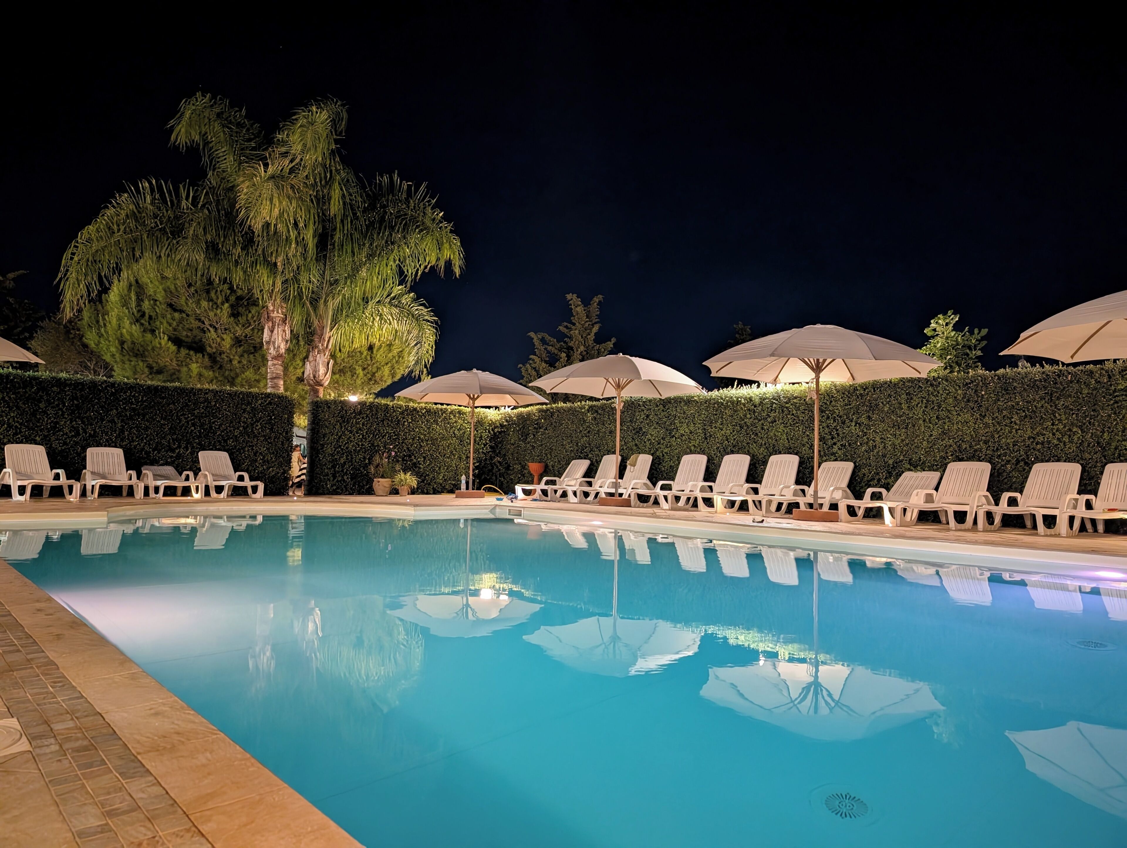 Una piscina al aire libre, sombrillas, tumbonas
