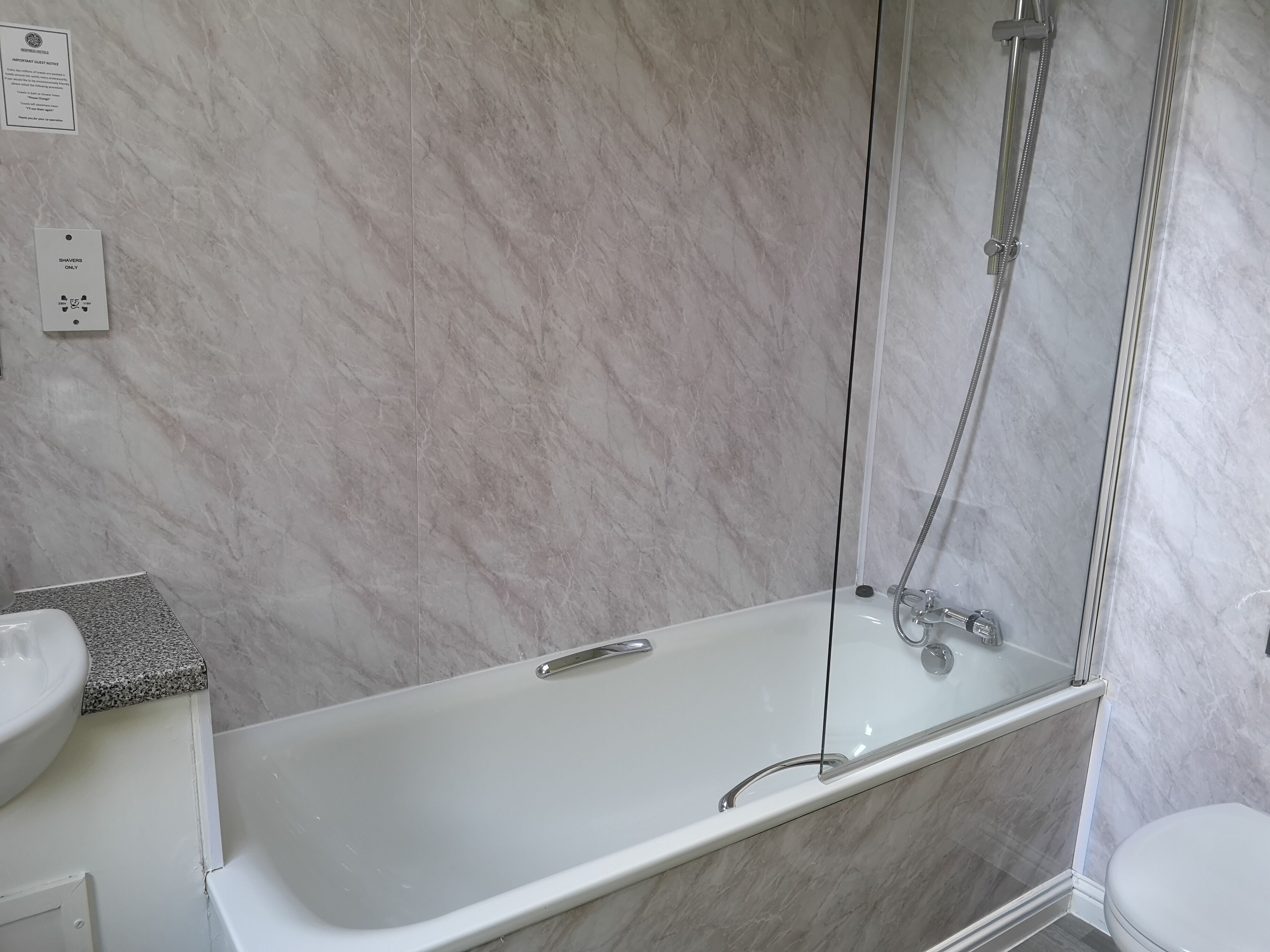 A bathroom with a bathtub, a shower, and a sink.