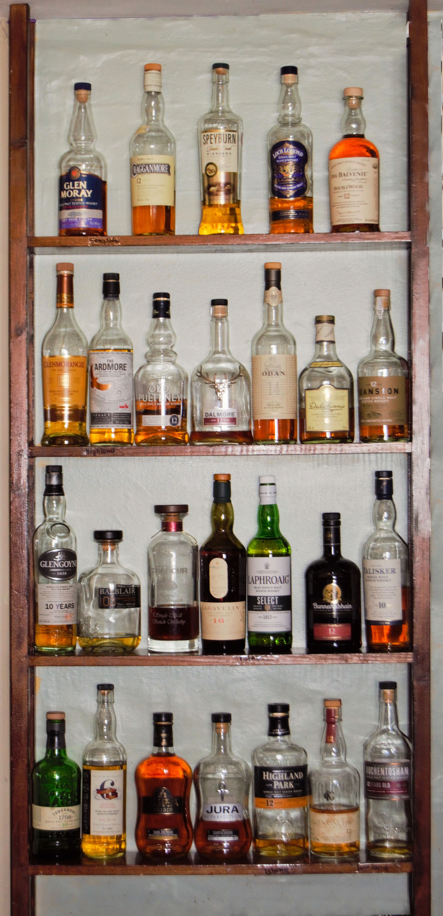 A display of various whisky bottles arranged on shelves.