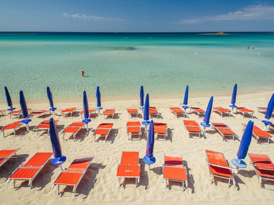 Praia particular, areia branca, espreguiçadeiras, guarda-sóis