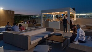 Een terras op het dak met zitplaatsen en een bar.