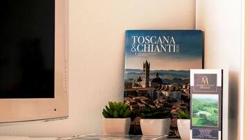Un livre intitulé « Toscane et Chianti » est posé sur une table, à côté d’une plante en pot et d’une brochure.