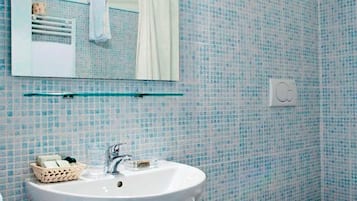 A bathroom with a white sink, a mirror, and a tiled wall.