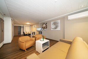 Suite – junior, 2 soverom, kjøleskap | Oppholdsområde | En 80-centimeters Flatskjerm-TV med digitale kanaler samt TV og leker