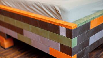 A bed with a multicolored headboard and a wooden floor.