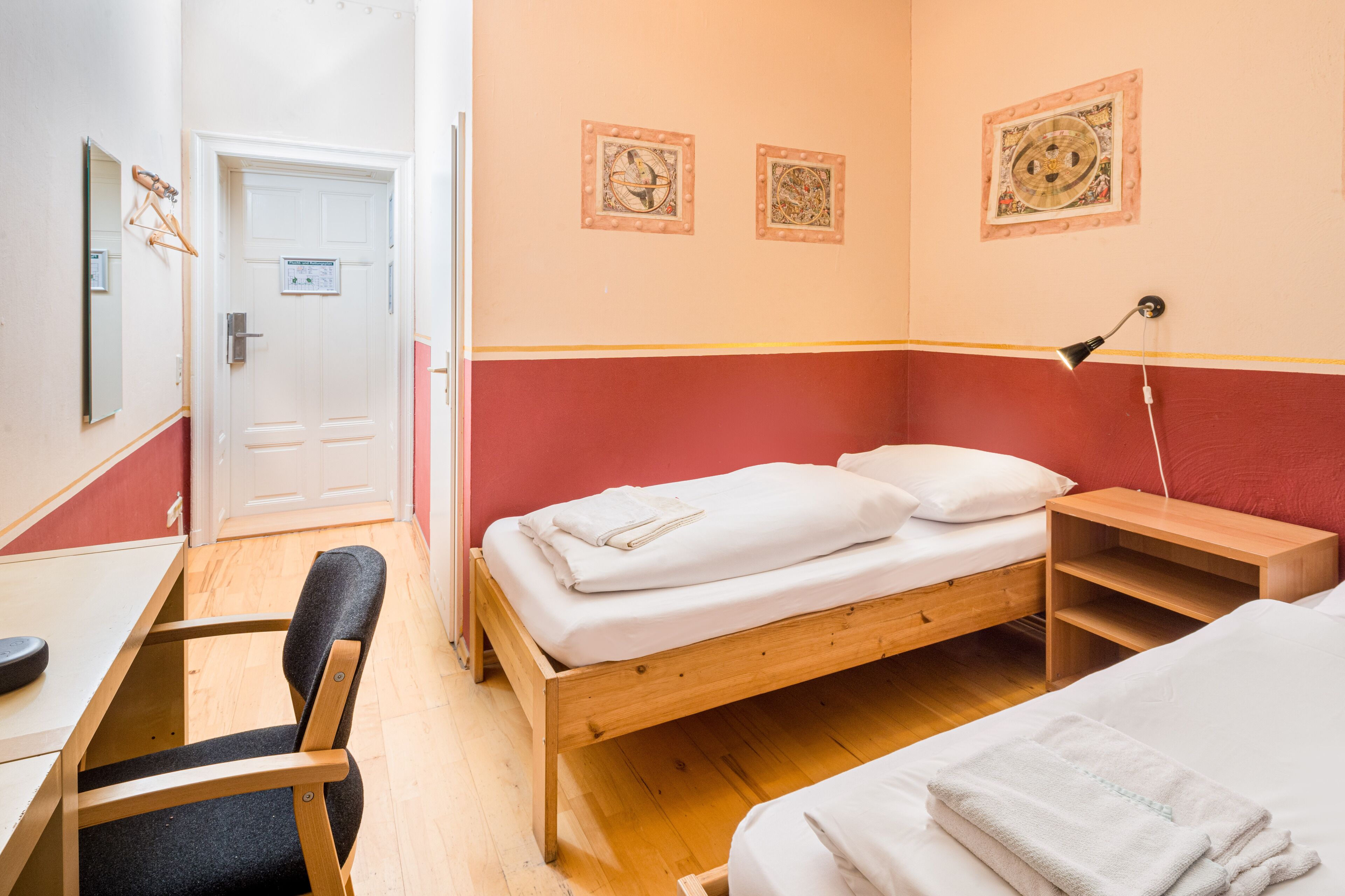 A room with a wooden bed, a desk, and a chair.