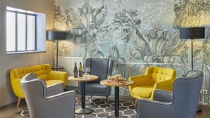 A modern living room with a yellow and grey sofa set, a round coffee table, and a patterned wall. - Le Nouvel (Portes-les-Valence)