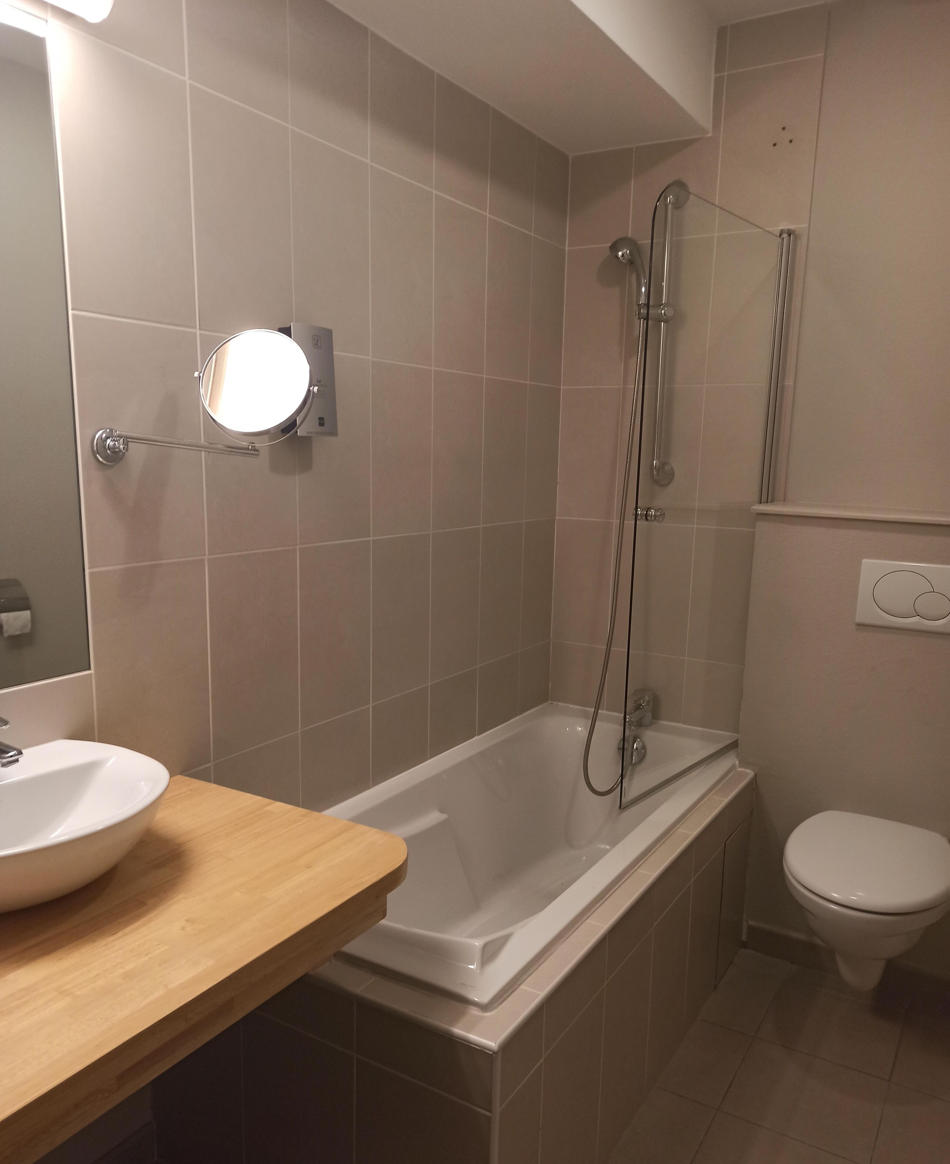 A bathroom with a bathtub, a toilet, and a sink.
