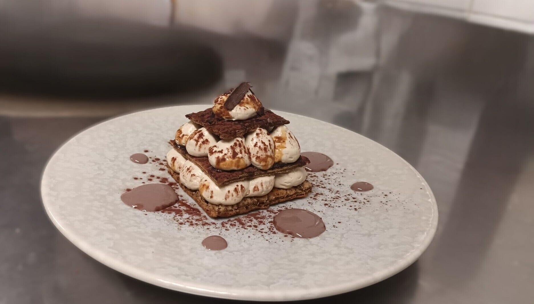 Un postre en un plato con capas de chocolate y malvaviscos, espolvoreado con cacao.